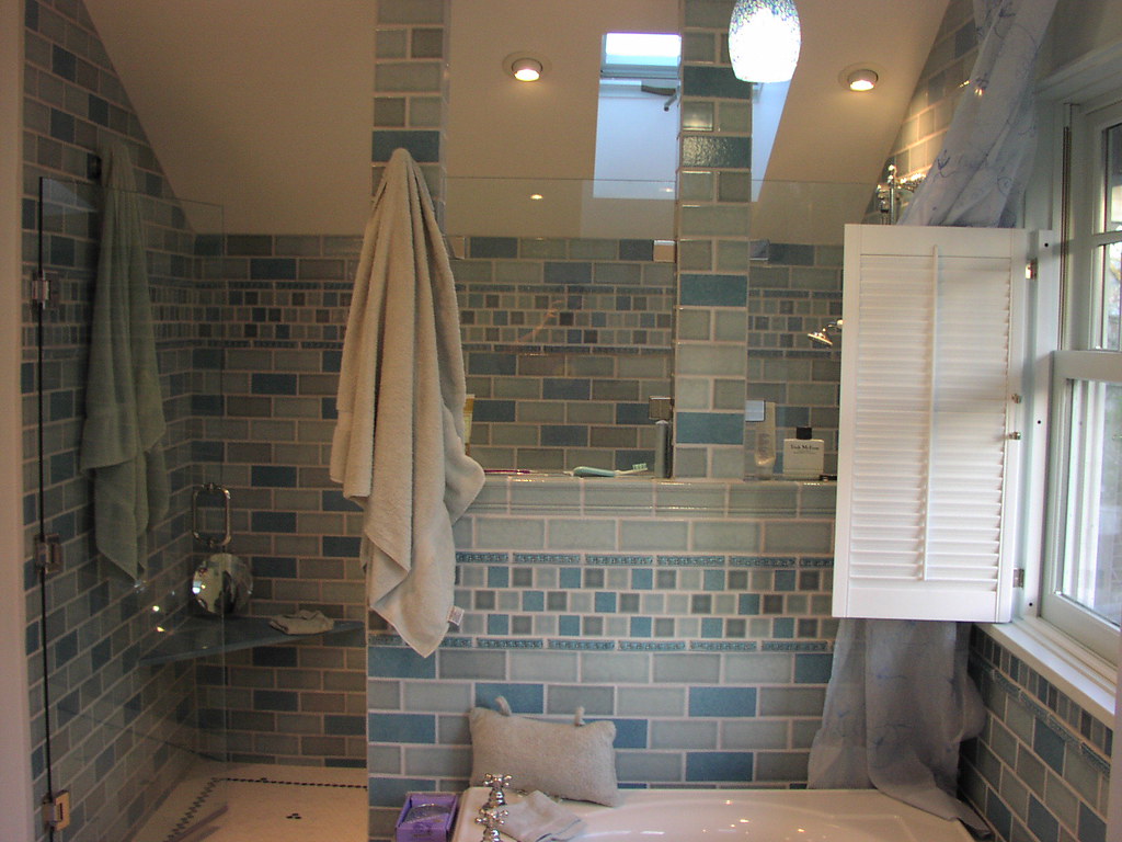 Fully tiled bathroom with a glass-screened shower and skylight