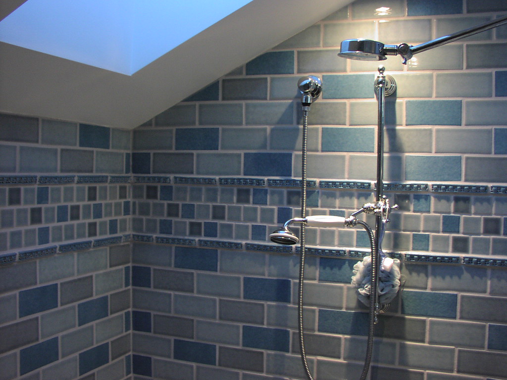 Blue subway-tiled shower wall with a rain shower head