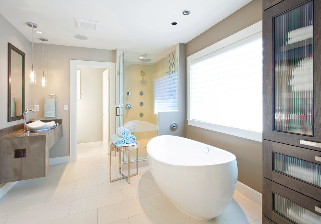 Modern bathroom with a freestanding tub, glass shower screen and large tiled floor